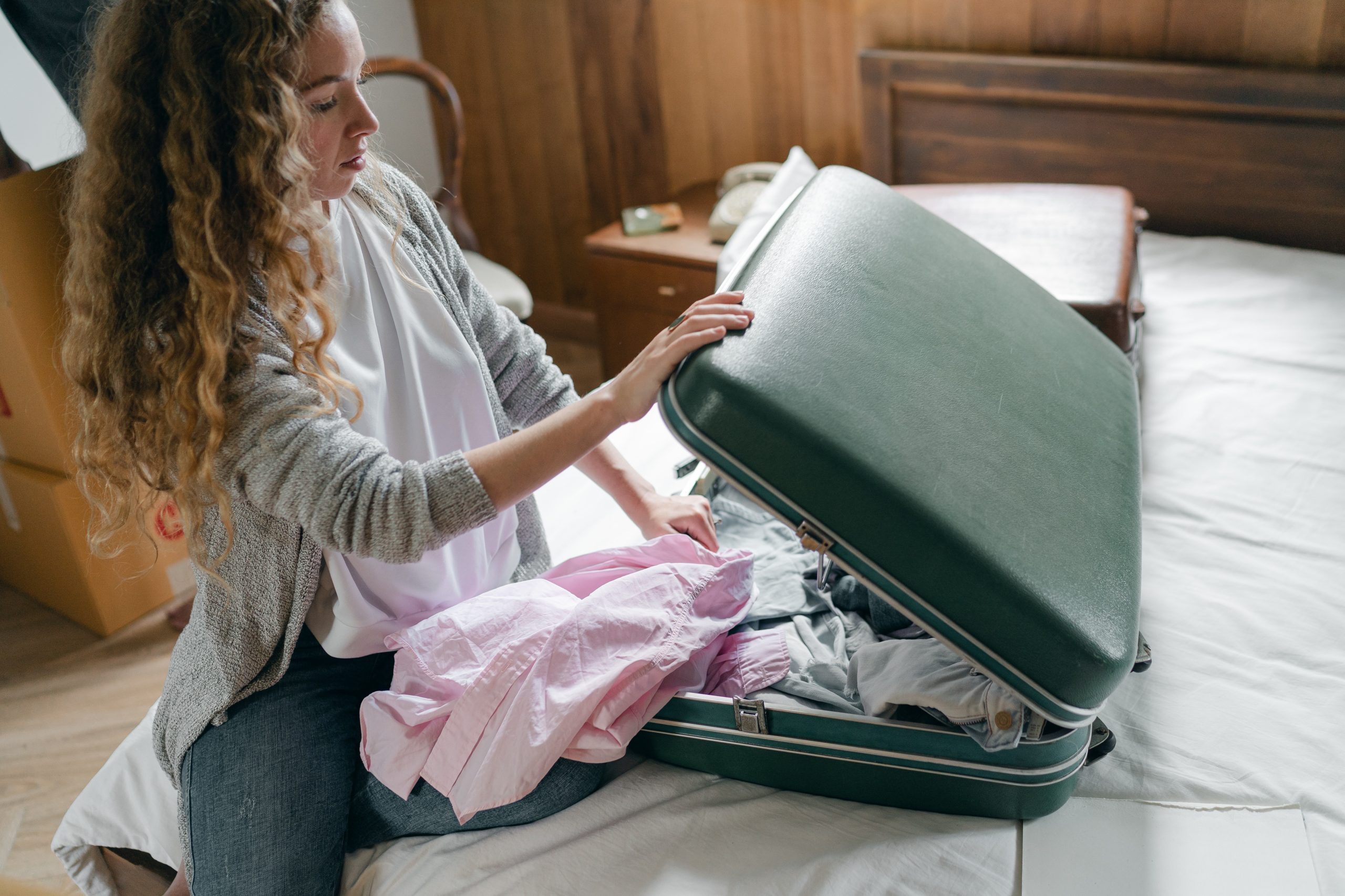 protect your home while you're on holiday - woman packing suitcase